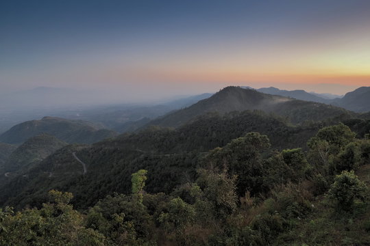 sunset at Doi Ang Khang, Mountain view evening of top hill around with soft fog and yellow sun light in the sky background, Monzone Camping Zone, Doi Angkhang, Chiang Mai, Thailand.