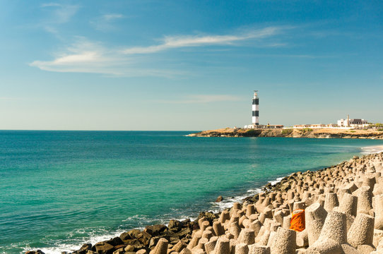 Lighthouse and wave breakers on the coast of the beautiful blue arabian sea