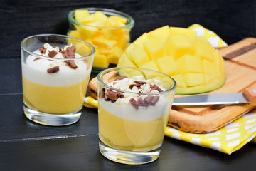 Mousse of mango in a glass jars on table