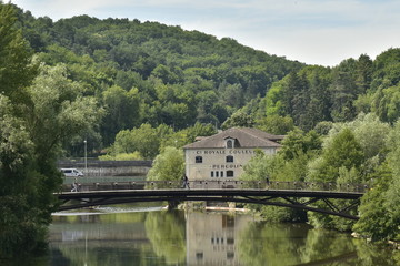 Fototapeta na wymiar Reflet parfait du pont métallique et d'un bâtiment historique dans l'Isle au fond d'une vallée verdoyante en aval de Périgueux en Dordogne