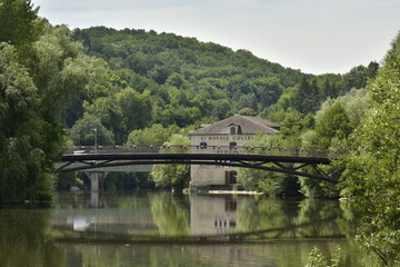 Fototapeta na wymiar Reflet parfait du pont métallique et d'un bâtiment historique dans l'Isle au fond d'une vallée verdoyante en aval de Périgueux en Dordogne