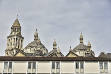 Fototapeta premium Les dômes de l'imposante cathédrale St-Front émergeant d'un bâtiment récent au centre historique de Périgueux en Dordogne