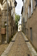 Fototapeta na wymiar Ruelle entre les vieux murs en pierres et historiques au centre ville médiévale de Périgueux en Dordogne