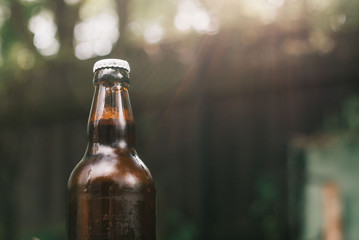 Holding cold beer at garden in hot summer evening