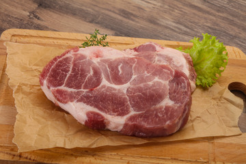 Raw pork steak over wooden board