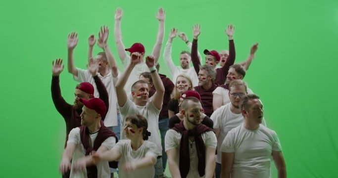 GREEN SCREEN CHROMA KEY Front view group of people fans wearing red clothes doing a wave during a sport event. 4K UHD ProRes 422 HQ