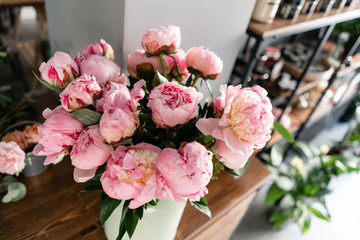 The counter of the flower shop. Pink peonies in a metal vase. Beautiful peony flower for catalog or online store. Floral shop concept . Beautiful fresh cut bouquet. Flowers delivery