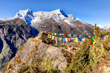 View at the prayers flags and Kongde Ri peak on the trek to Everest base camp,  Nepal.
