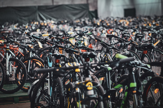 A lot of new bicycles are standing at warehouse waiting for customers.