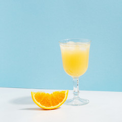 Fruit berry drink in a glass with ice on a colored background.