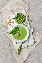 Soup of green peas with basil leaves and croutons