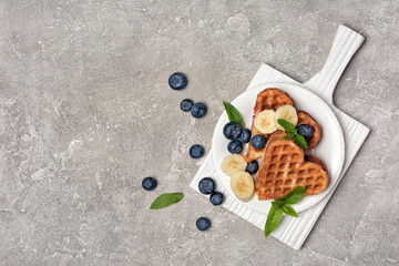 Top view of belgian waffles with fresh berries and fruits