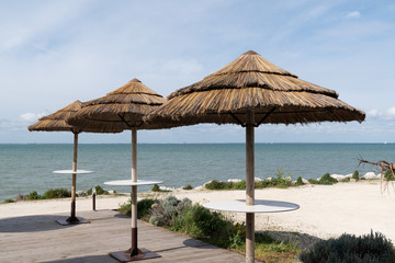 Fototapeta na wymiar beach cafe with straw parasols