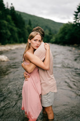 Fototapeta na wymiar Lifestyle loving couple hugging in the river