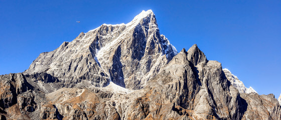 Helicopter flying between Himalayan peaks, view at Everest Base Camp trek in Nepal