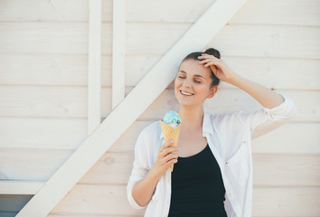 Young happy woman enjoying ice-cream on wooden background. Summer time