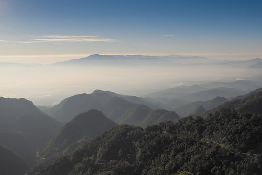 Mountain view misty morning of top hill around with sea of mist and blue sky background, sunrise at Doi Ang Khang, Monzone view point, Chiang Mai, Thailand.