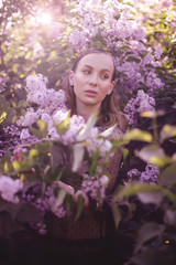 Young beautiful woman with fantasy make up posing with lilac flowers