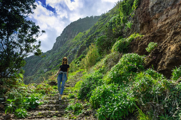 Naklejka na ściany i meble Beautiful woman walking on mountain coastline of Madeira island