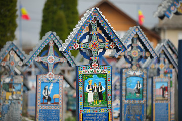 Obraz premium Vivid painted wooden tombstones at Merry Cemetery, Famous graveyard in Sapanta, county of Maramures, Romania