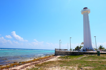 Playa, costo donde se puede ver faro con cielo muy azul