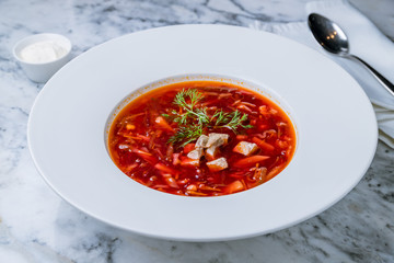Borscht with sour cream on a white plate