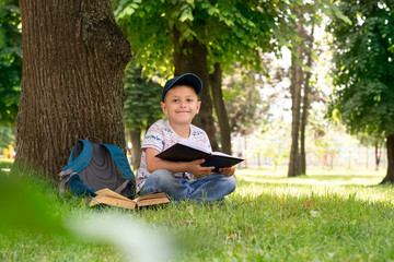 boy in the park reading a book