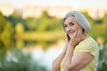 Portrait of happy senior beautiful woman by lake