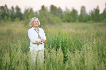 Portrait of happy senior beautiful woman posing in spring park © aletia2011