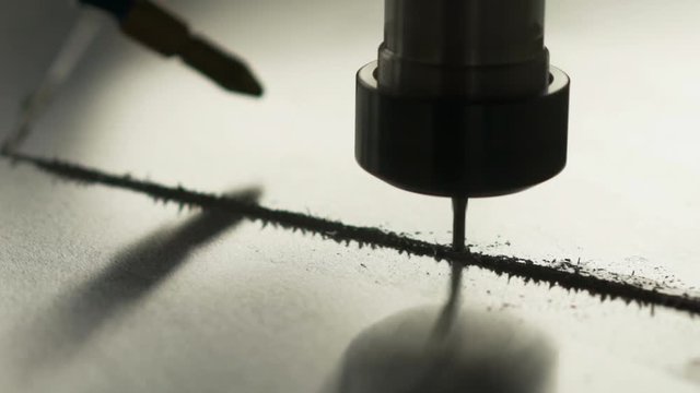 Pan around a CNC machine drilling in a metal sheet