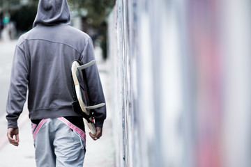 Rear view of  person carrying surfboard on street