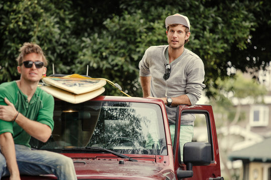 Young Men Pose In Car With Surfboards