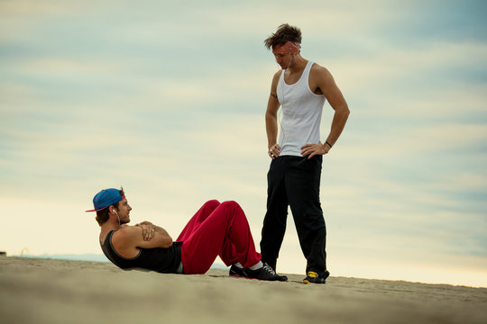 Man watching friend do crunches