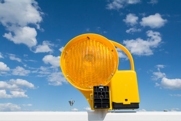 Gelbe Baustellenlampe vor blauem Himmel