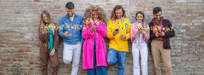 Group of diverse friends using social media on their mobile phones, with emoticons popping up from...