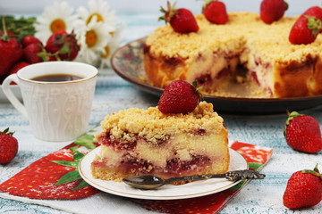 Cake with cottage cheese with strawberries is located on a blue background, a piece of cake is located in the foreground on a plate