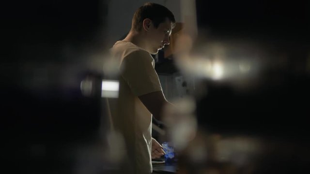 Man coloring paint in the building shop stock. craftsman in uniform putting bucket with paint into the machine for color in the printing shop silkscreen
