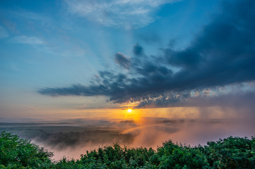 Sunrise on a foggy summer morning over the village