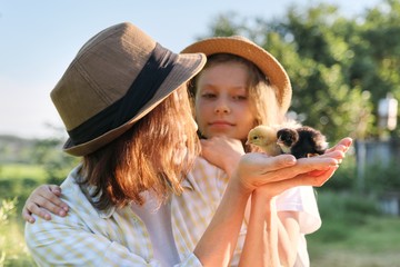 Country rustic style, happy mom and daughter together with newborn baby chickens.