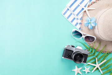 Beach accessories retro film camera, sunglasses, flip flop starfish beach hat and sea shell on...