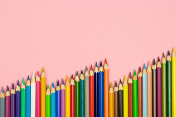 Close up of color pencils on pink background with clipping path. Education frame concept.
