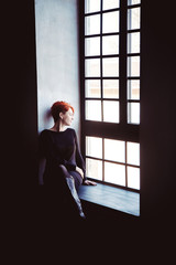 Fototapeta na wymiar Red haired woman, sofa, arm-chair and silhouette on the window