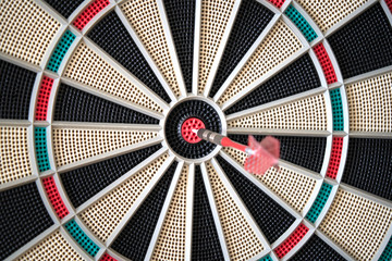 Closeup of dart board with dart in the bulls eyes.