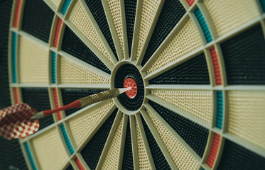 Obraz premium Closeup of dart board with dart in the bulls eyes.