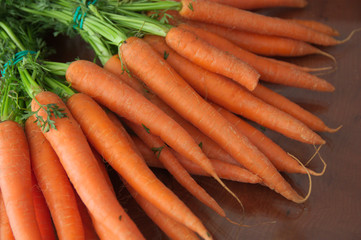 Many carrots on a dark wooden table