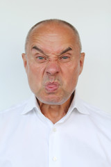 bald old man in white shirt showing tongue, close-up