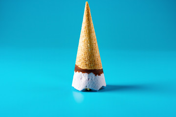peanut ice cream cone upside down on a blue background