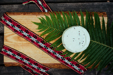 Latvian cheese with fern and national belt - obrazy, fototapety, plakaty