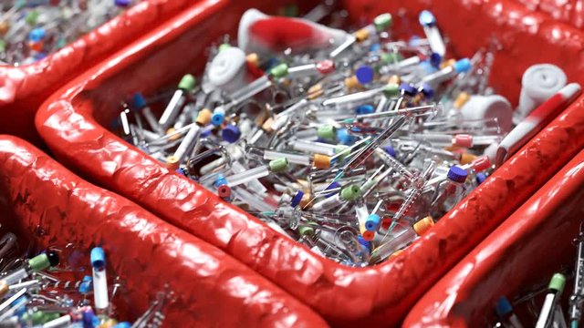 Medical waste in trash cans. Red bin liner. Hospital garbage. Gauze and syringes