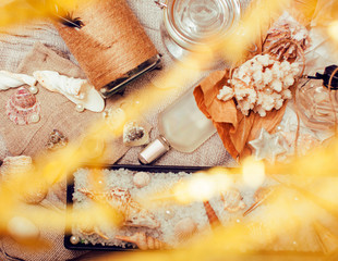 a lot of sea theme in mess like shells, candles, perfume, girl stuff on linen, pretty textured post card view vintage close up